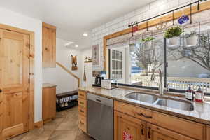 Kitchen featuring light stone counters, stainless steel dishwasher, and recessed lighting