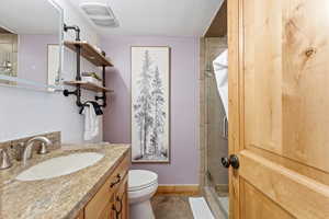 Bathroom featuring a stall shower, vanity, and a textured ceiling