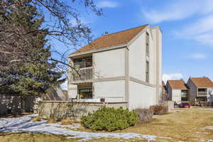 Rear view of property with a balcony and stucco siding
