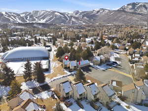 Snowy aerial view featuring a mountain view and a residential view