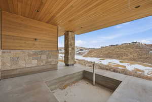 Snow covered patio with a patio area