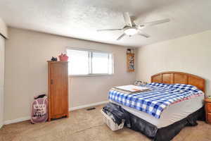 Bedroom with light carpet and a ceiling fan