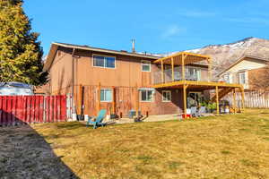 Rear view of property featuring a patio area, a fenced backyard, and a deck with mountain view
