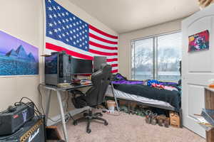 Carpeted bedroom with a desk