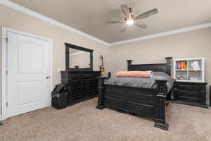 Bedroom featuring light carpet, ornamental molding, and ceiling fan