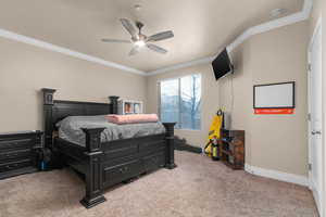 Bedroom with ornamental molding, light carpet, and a ceiling fan