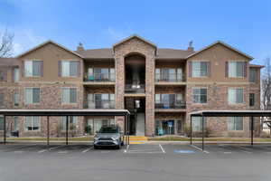 View of apartment building / complex with covered parking