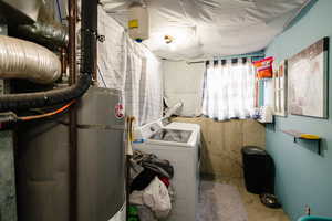 Laundry area with concrete floors and washer and clothes dryer