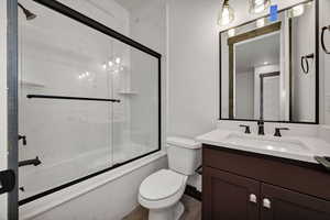 Full bath with enclosed tub / shower combo and vanity