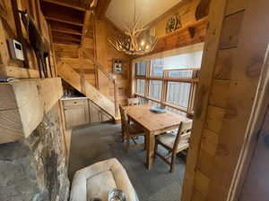 Dining area with wood walls, hanging lights, and lofted ceiling