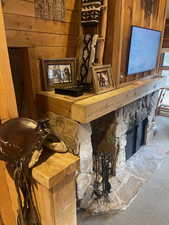 Detailed view of carpet floors, wooden walls, and a stone fireplace