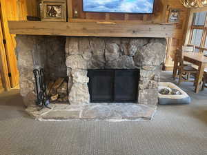 Detailed view of wooden walls, carpet floors, and a fireplace