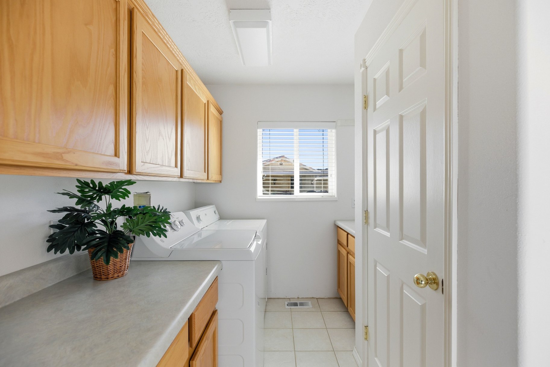 Laundry room with cabinet space, washing machine and dryer, and light tile patterned floors