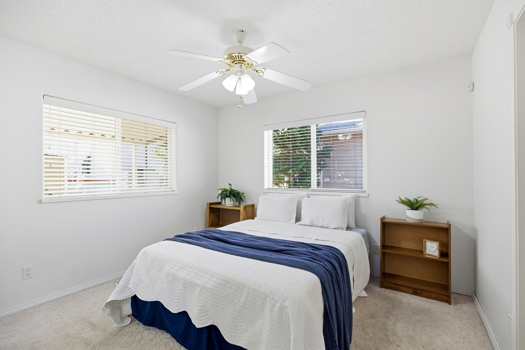 Bedroom with light colored carpet and a ceiling fan