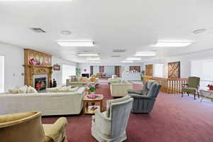 Carpeted living room featuring a fireplace and a textured ceiling