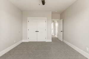 Unfurnished bedroom with carpet flooring, a closet, and a ceiling fan