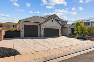 View of front of house featuring a garage, board and batten siding, concrete driveway, a gate, and a tile roof