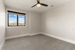Empty room with light carpet and a ceiling fan