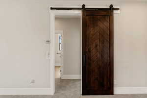 Hallway with carpet flooring and a barn door