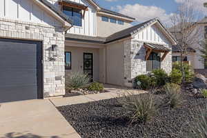 View of exterior entry with stone siding and board and batten siding
