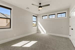 Unfurnished room with ceiling fan, light carpet, and healthy amount of natural light