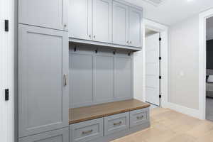Mudroom with light wood finished floors and baseboards