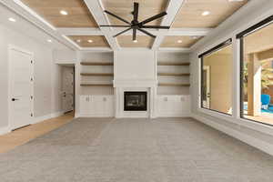 Unfurnished living room with a ceiling fan, coffered ceiling, a large fireplace, and recessed lighting