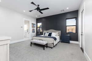 Bedroom with light carpet, a decorative wall, a ceiling fan, recessed lighting, and ensuite bath