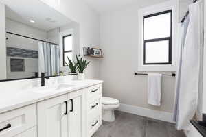 Bathroom with vanity, curtained shower, and light tile patterned floors