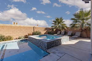 Integrated pool / spa featuring a fenced backyard and a patio
