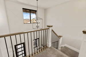 Stairway featuring a chandelier and carpet flooring