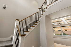 Stairs with coffered ceiling and a ceiling fan