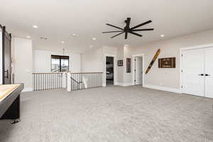 Unfurnished room with ceiling fan, light colored carpet, recessed lighting, and a barn door