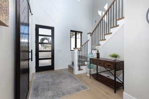 Foyer entrance featuring light wood-style floors and a high ceiling