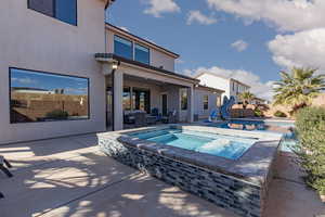 Swimming pool with a water slide, an in-ground hot tub, a fenced backyard, and a patio
