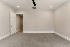 Unfurnished room featuring light colored carpet, a ceiling fan, and recessed lighting