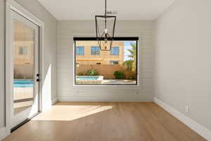 Unfurnished dining area with light wood-style floors and wood walls
