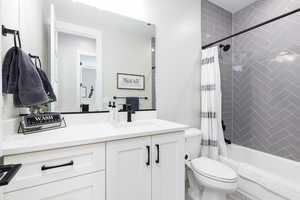 Full bathroom featuring shower / bath combination with curtain and vanity
