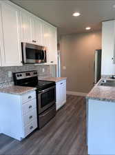 Kitchen with stainless steel appliances, white cabinetry, light countertops, and recessed lighting