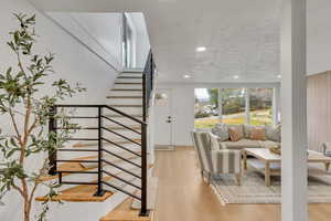Stairs with wood finished floors and recessed lighting