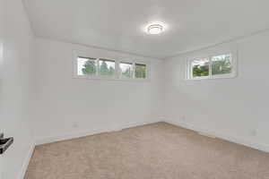 Carpeted spare room featuring baseboards