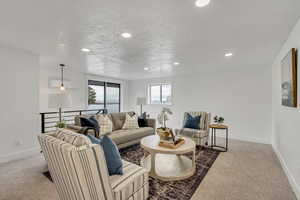Living area featuring light colored carpet and recessed lighting