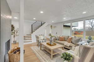 Living room with light wood-style flooring, recessed lighting, and a textured ceiling