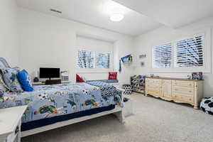 Bedroom featuring a textured ceiling and light colored carpet