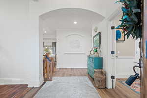 Foyer entrance featuring arched walkways, wood finished floors, recessed lighting, and ornamental molding