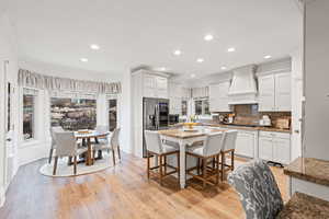 Dining space with crown molding, light wood-type flooring, and recessed lighting