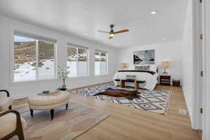 Bedroom with recessed lighting, light wood-style floors, a ceiling fan, and a textured ceiling