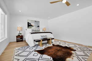 Bedroom featuring light wood finished floors, ceiling fan, and recessed lighting