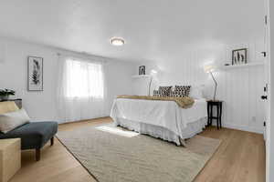 Bedroom featuring light wood finished floors and a textured ceiling