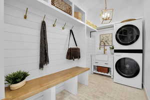 Laundry area featuring stacked washer / dryer and hanging lights